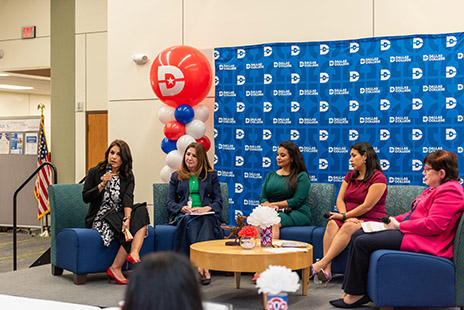 Ramos speaking while on a panel with three other women.