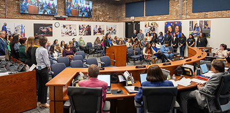 Leticia Laranjeira speaking at podium during board meeting