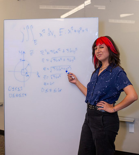 Maris Rodriguez standing at whiteboard.