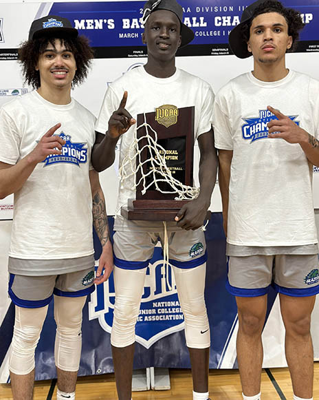 Three North Lake basketball players pose with trophy.