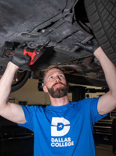 Chris Manning working underneath a car.
