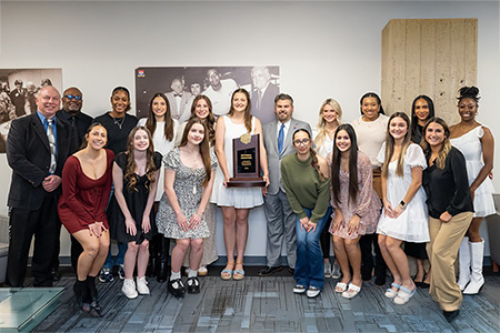 Eastfield Volleyball team holding trophy poses with coaches and Dr. Justin Lonon