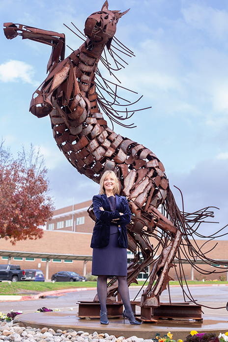 Christa Slejko standing in front of horse sculpture