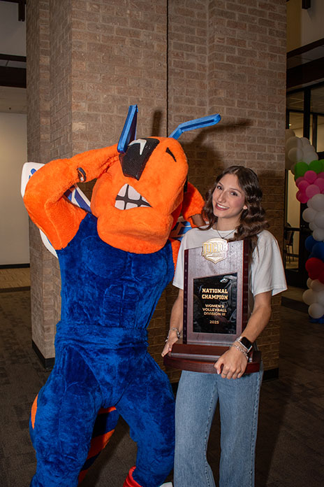Mia Santos poses with harvester bee mascot and NJCAA trophy.