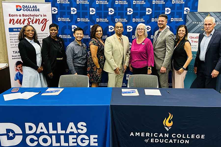 Group of officials standing behind two tables.