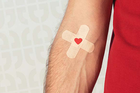 An image of a person's arm with a Band-Aid after donating blood.