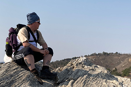 Corey Lyons is photographed looking out over a mountainous landscape