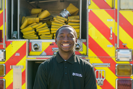Jermaine Lewis stands in front of a fire truck