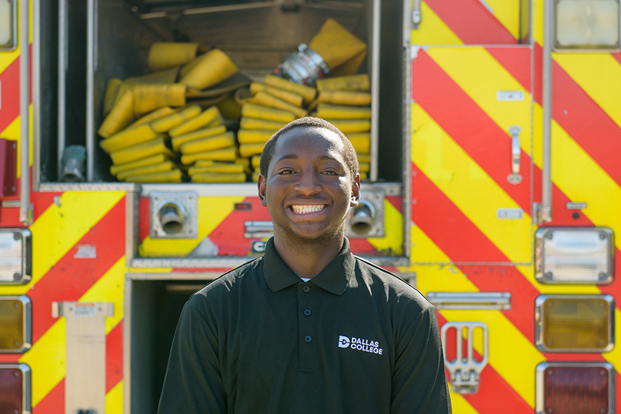 Jermaine Lewis stands in front of a fire truck