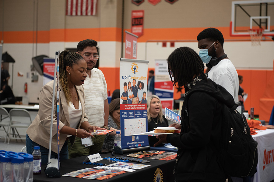 Students at job fair talking to table presenters