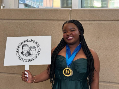 Student Faith Lungu poses with scholarship sign