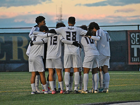 Richland men's soccer team in huddle on field.