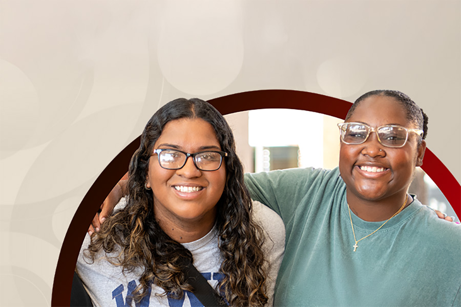 Two students smiling with arms around each other