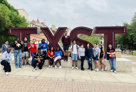 Students pose in front of TXST sign