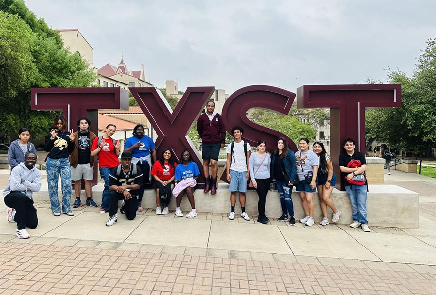 Students pose in front of TXST sign