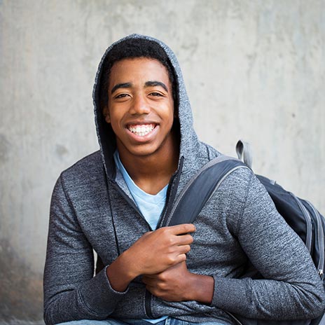 High School student in gray hoodie with black backpack