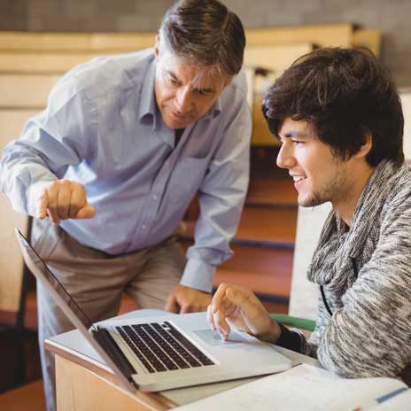 college staff helping student on their laptop
