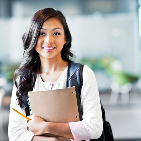 College student wearing backpack is holding a folder and pencil