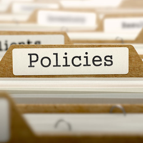 Close-up of a file folder labeled 'Policies' in an organized filing system