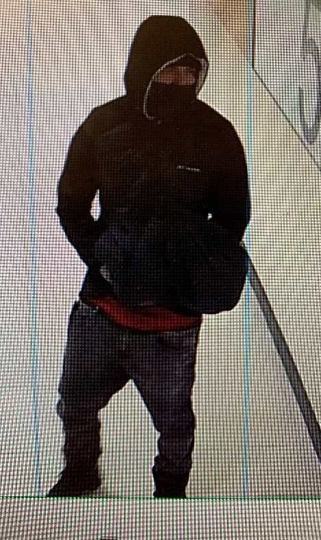 young hispanic man in black jacket with black mask.