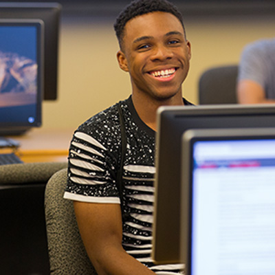 A student looks over their computer monitor