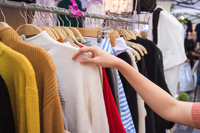 Picture of someone looking through a clothing rack