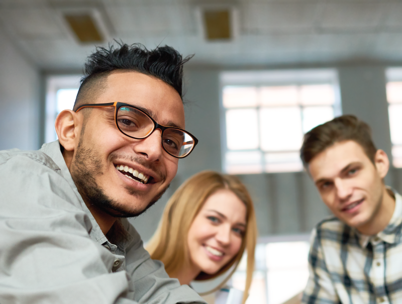 four students smiling and sitting together