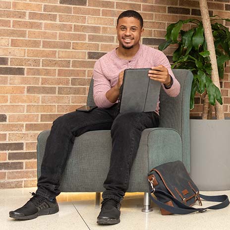 Student sitting down smiling