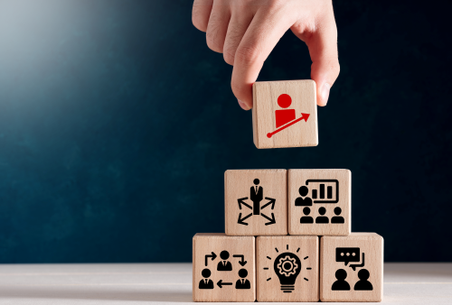 A hand placing a block on top of five other blocks.