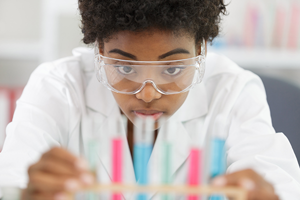 Photo of a student behind a set of test tubes