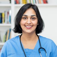 A nurse with a stethoscope smiling at the camera