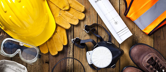 construction worker gear laid out on a wooden floor