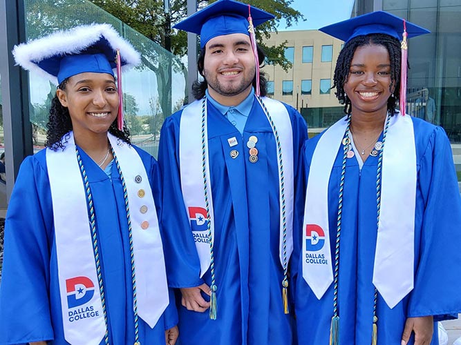 Three STEM League graduates pose for a photo at graduation