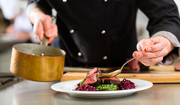 Closeup of a plate as a chef plates a meal