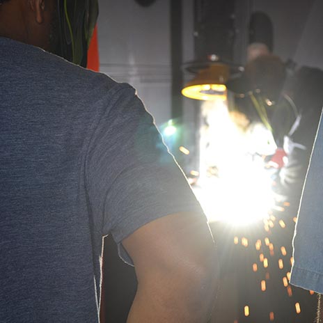 sparks fly as a student welder works on a project