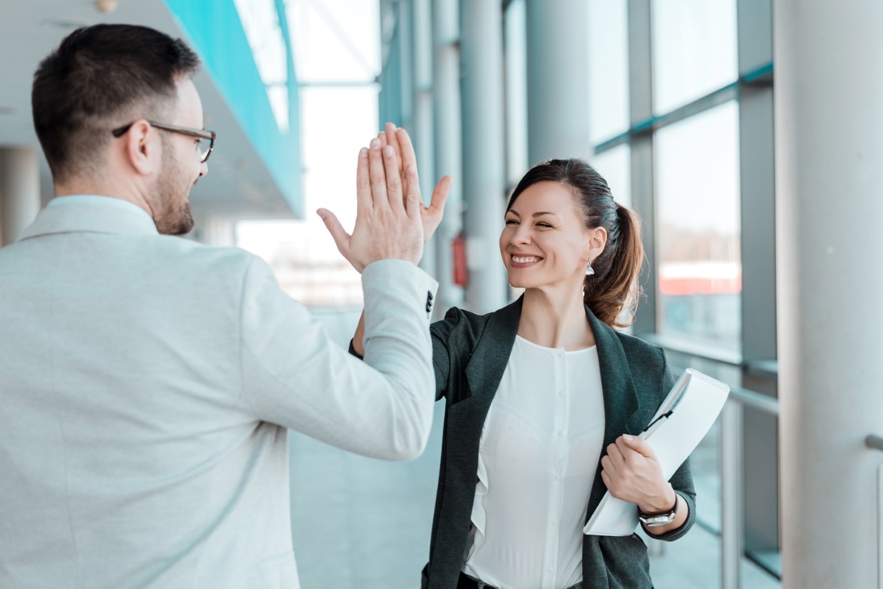 Female and male giving each other a high five