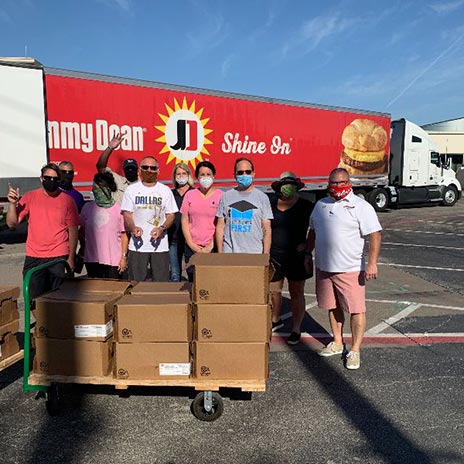 people and boxes in front of a truck that says 