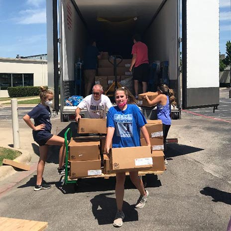 people unload boxes of food from a truck