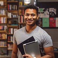 Photo of a student holding a tablet computer and smiling