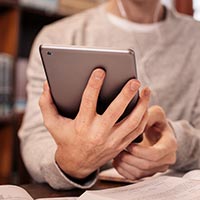 Close-up photo of a student holding a tablet computer