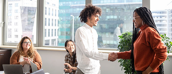 male and female shaking hands and smiling