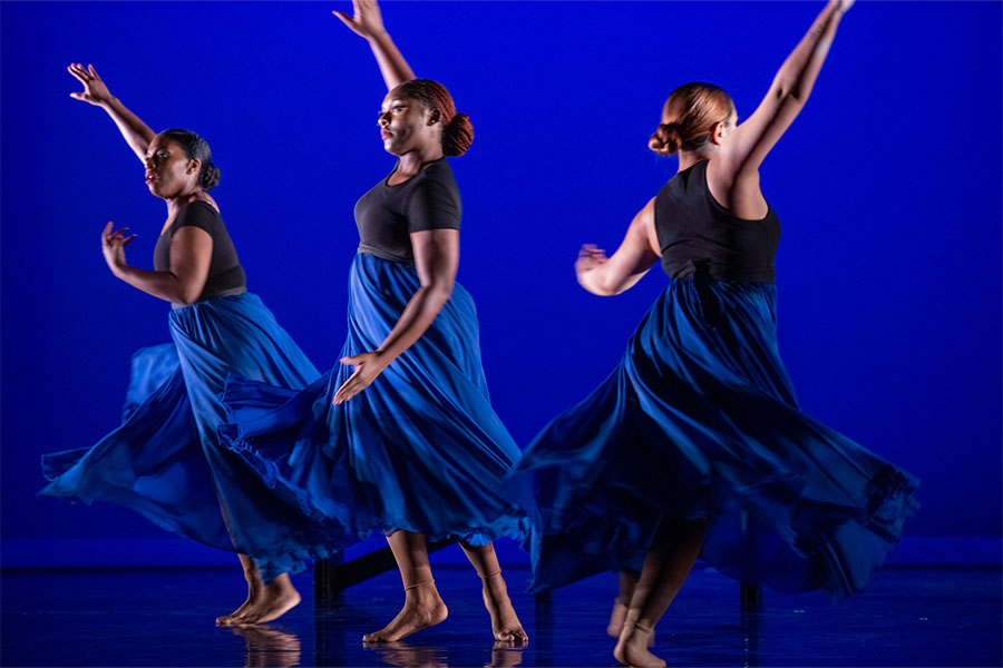 Dancers on stage with a blue background