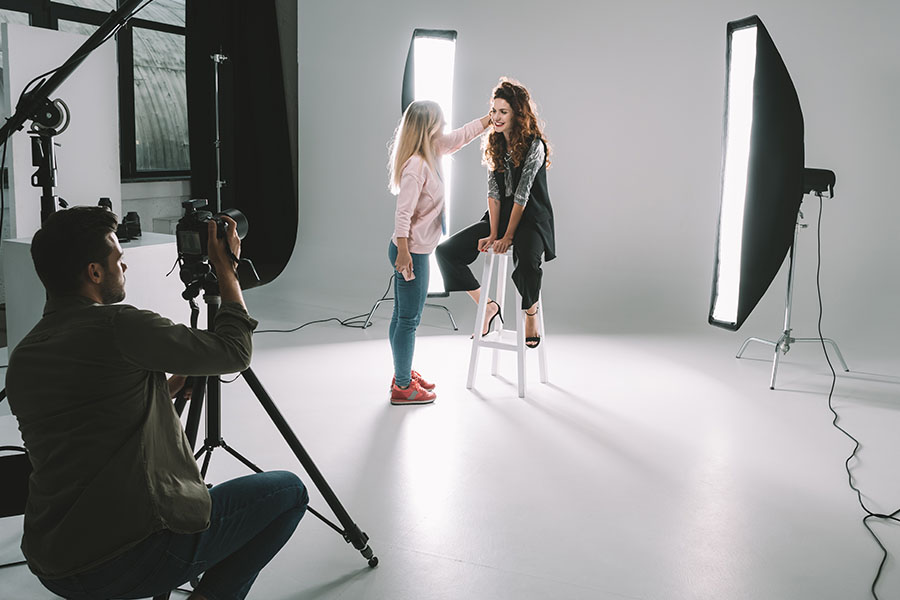 Photographer in studio coaching a model