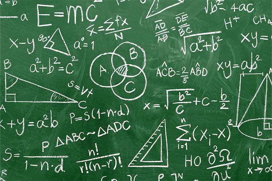 Green chalkboard covered with math equations, formulas, and geometric diagrams written in white chalk.